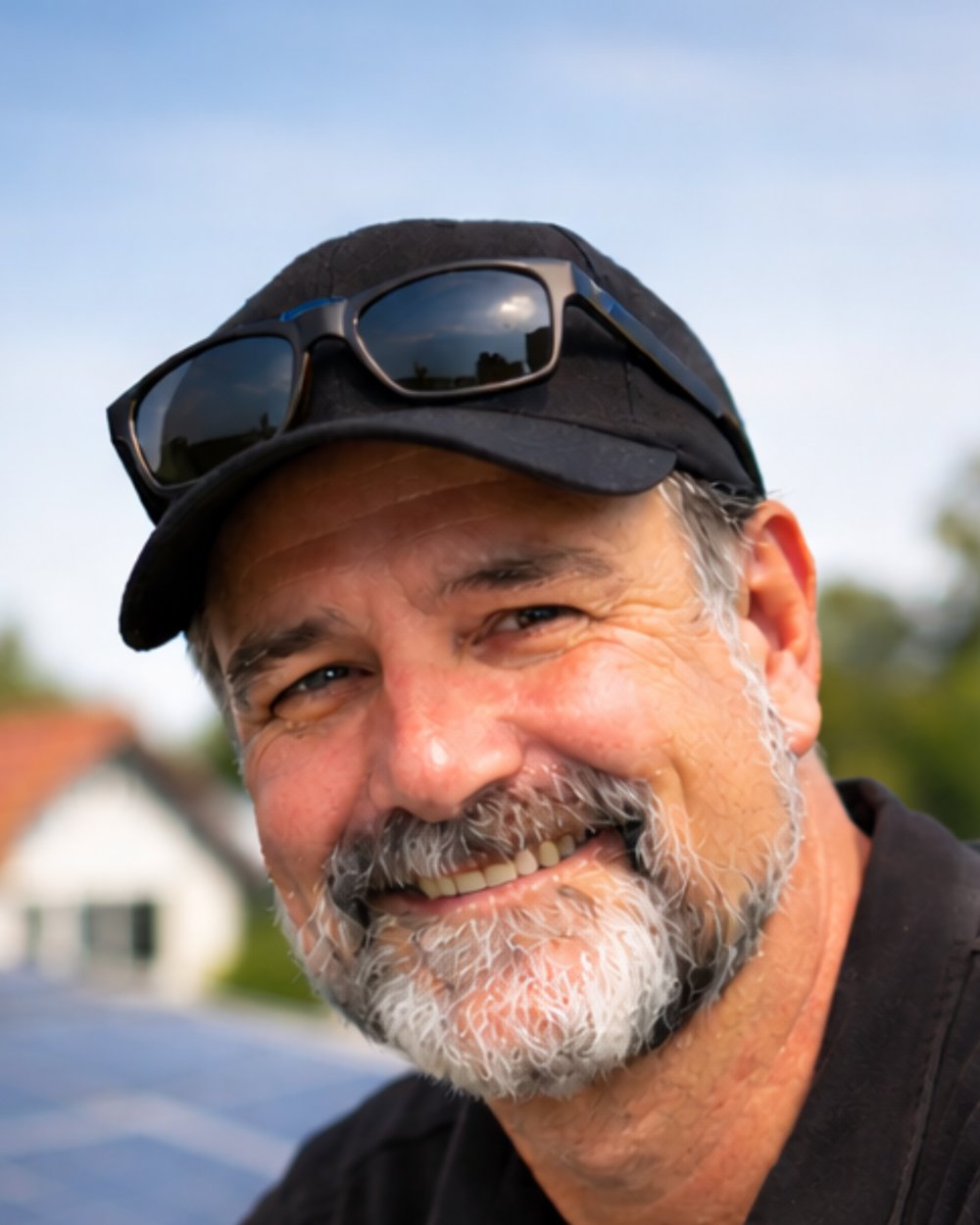 Dirk Keller im Freien vor einem Dach mit Photovoltaikmodulen